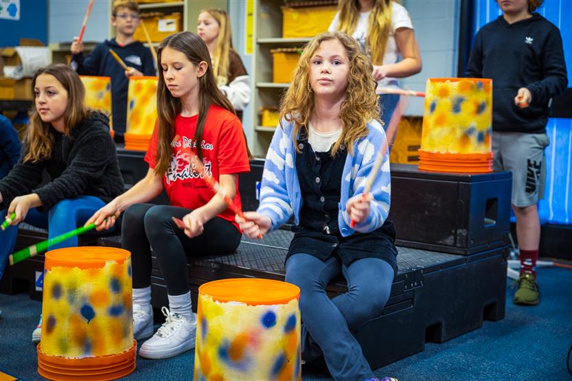 Students play drums in music class